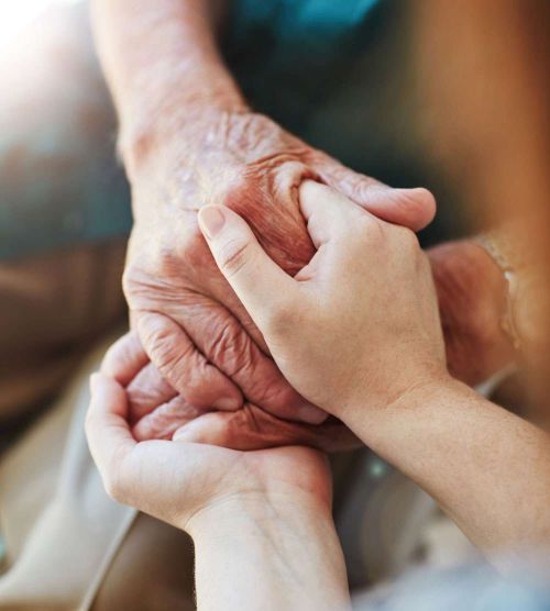 carer and resident's hand in hand 